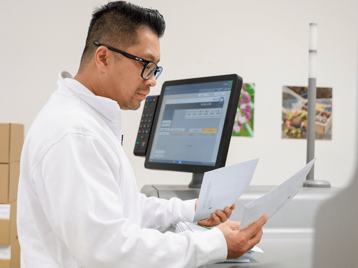 Mann überprüft sorgfältig Daten auf Ausdrucken